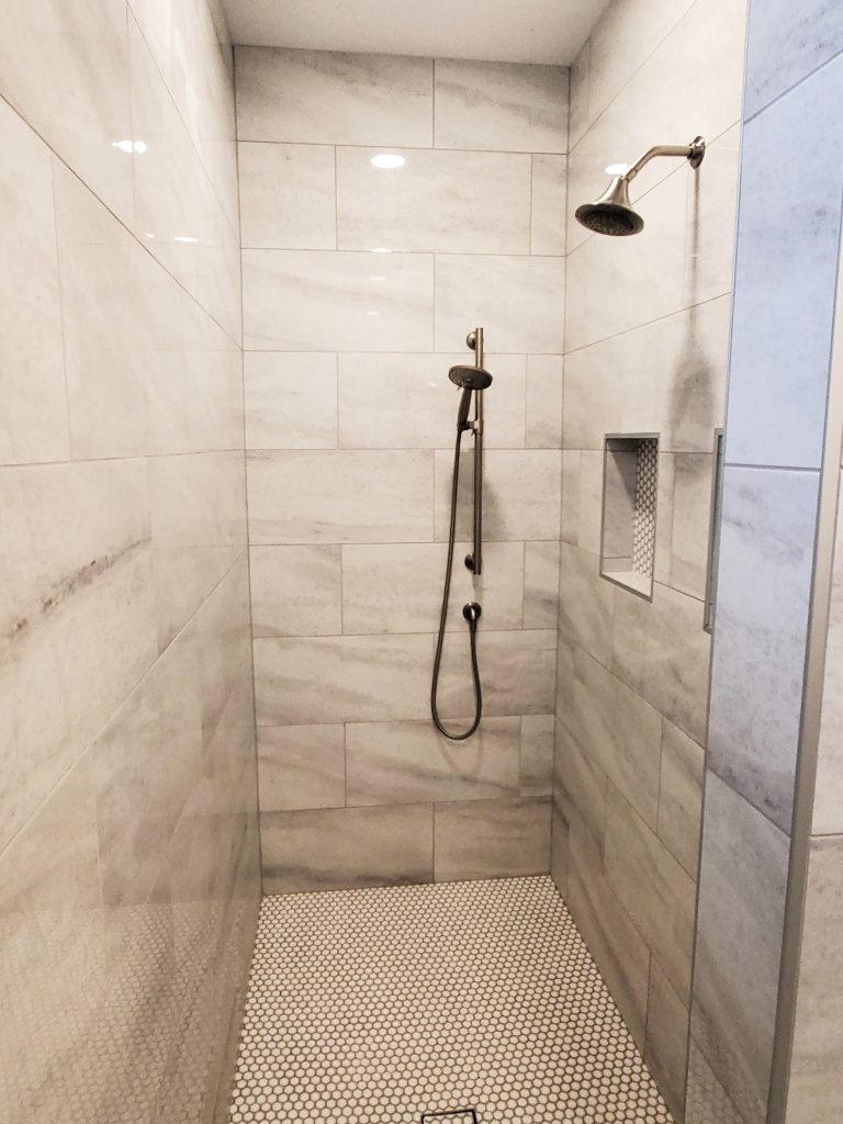 Modern tiled walk-in shower with handheld sprayer