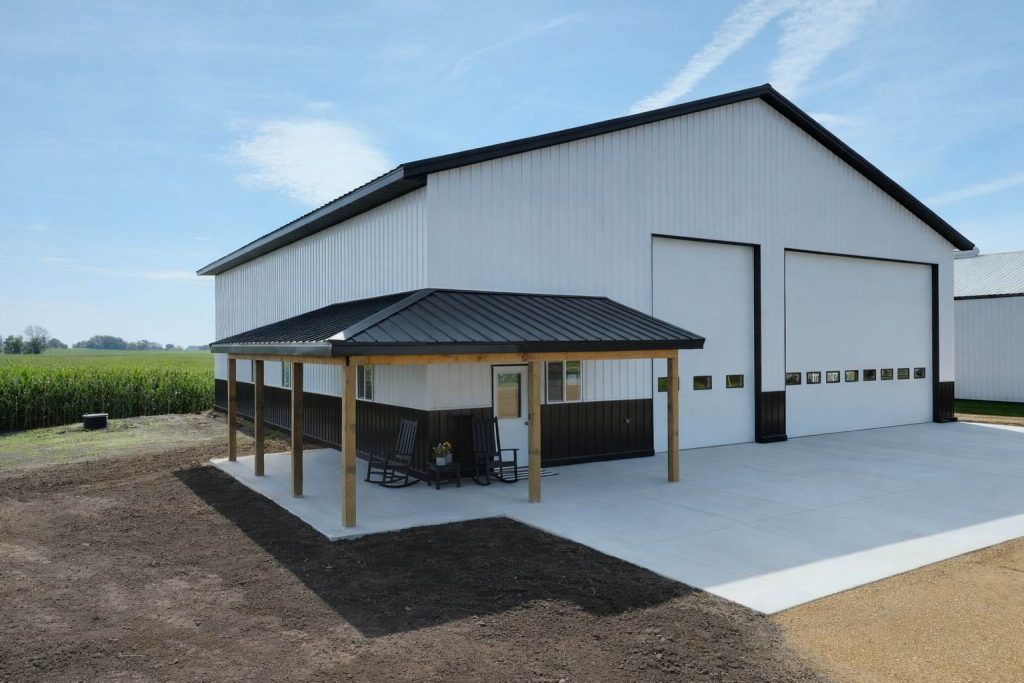 Modern white metal barn with porch and garage doors