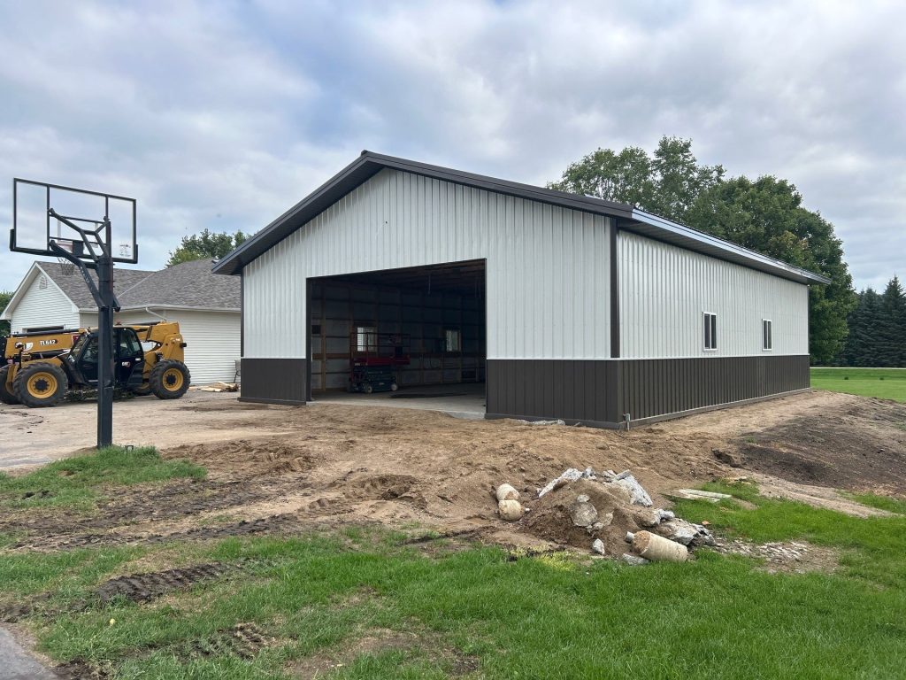 New metal pole barn with open garage door