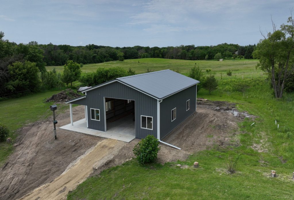 Gray metal barn in rural grassy landscape