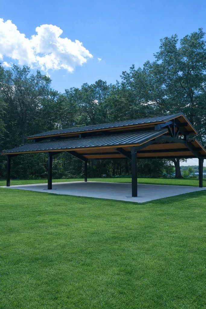 Open-air pavilion with metal roof in grassy park