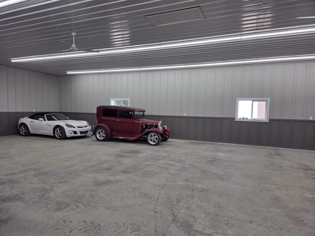 White convertible and red vintage car in garage