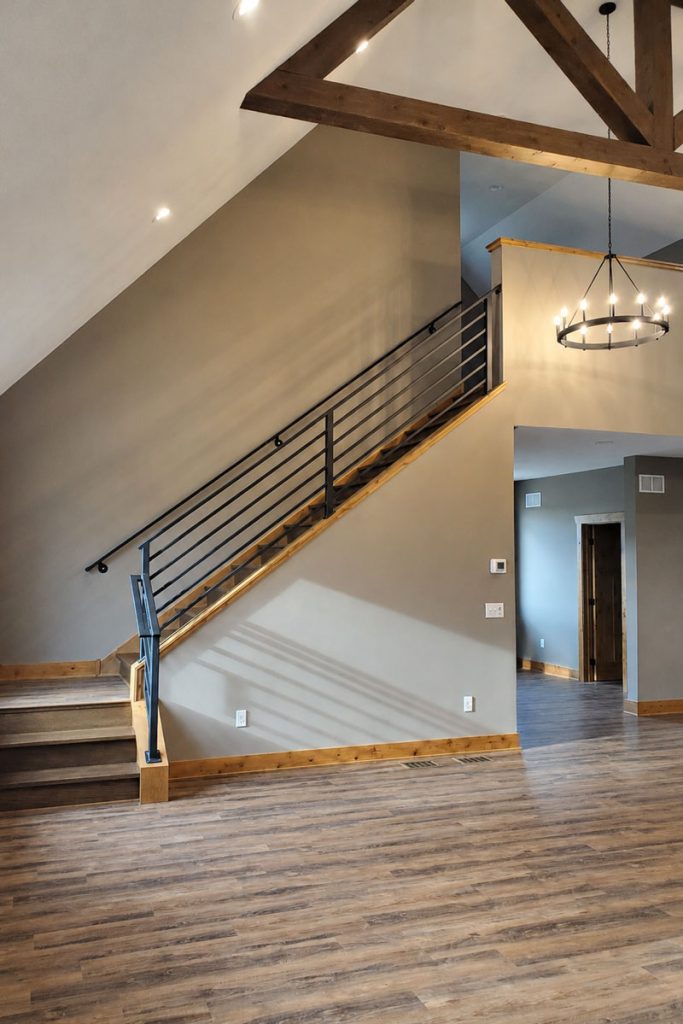 Modern staircase with metal railing and vaulted ceiling