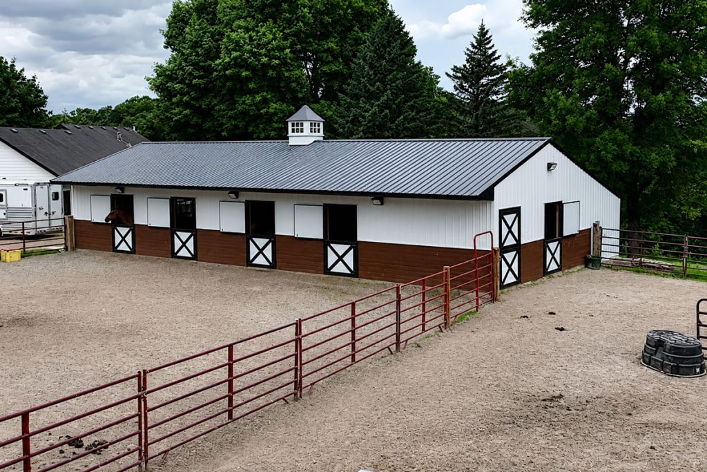 Horse stable barn with fenced paddock and stalls