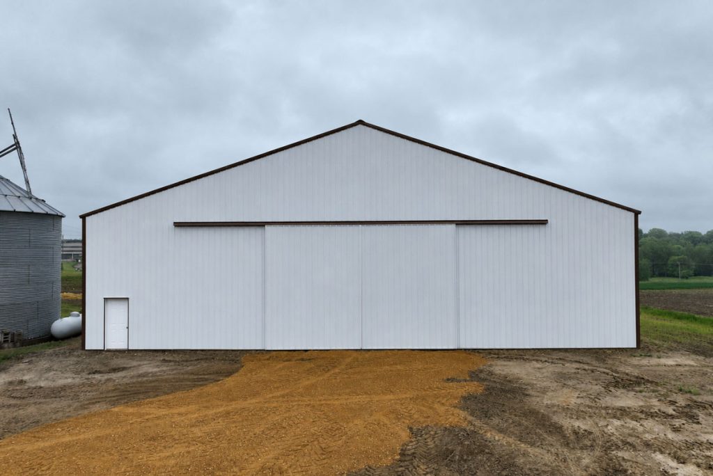 Large white metal barn on rural farmland