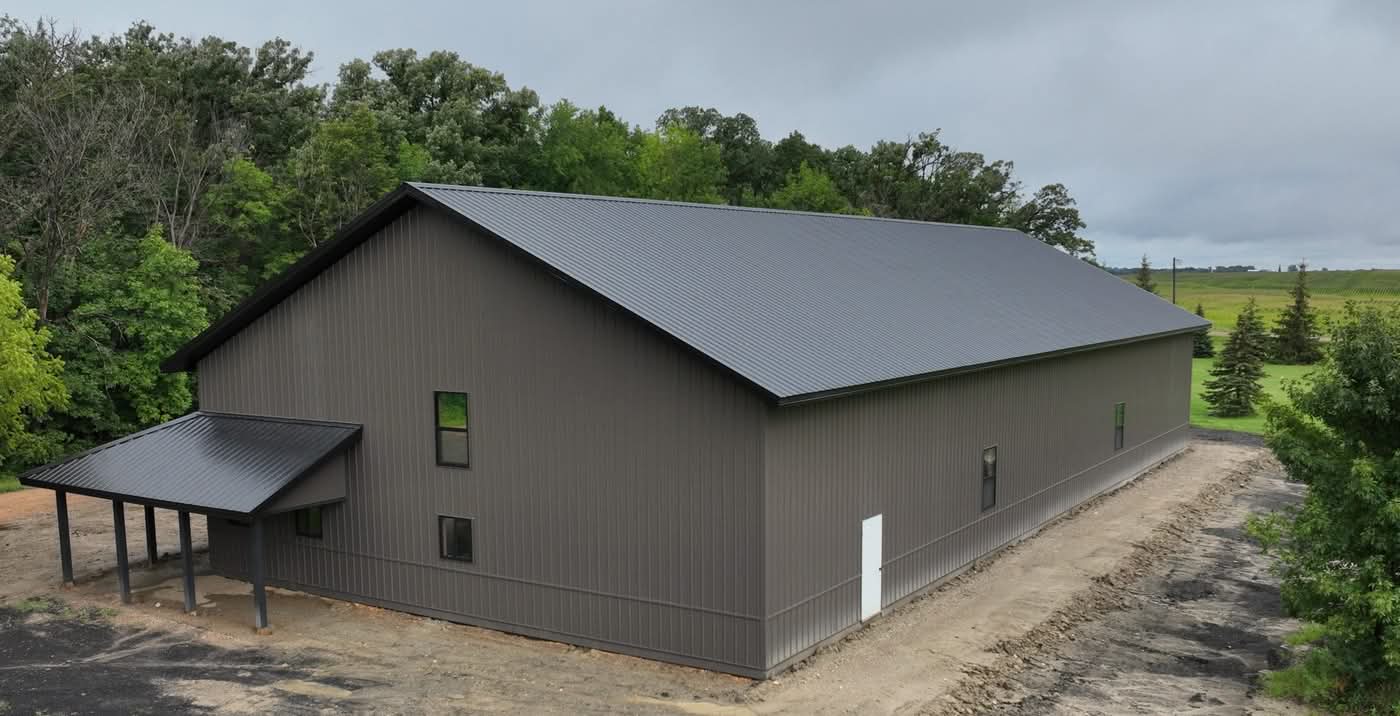 Large gray metal barn in rural landscape